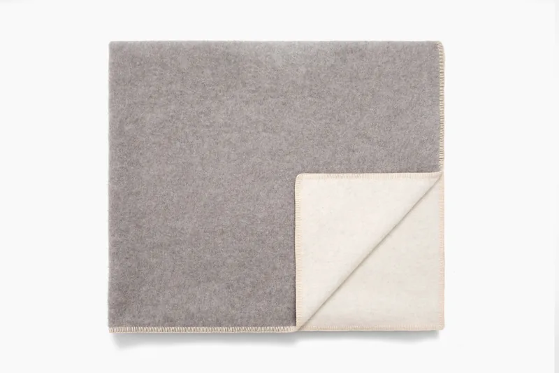 Twin blanket in grey, folded corner with blanket-stitch edge